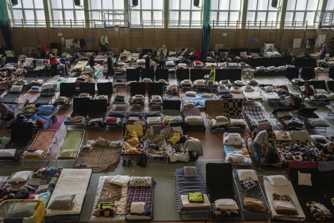 People who fled the war in Ukraine rest inside an indoor sports stadium being used as a refugee center, in the village of Medyka, a border crossing between Poland and Ukraine, on March 15, 2022. (AP)