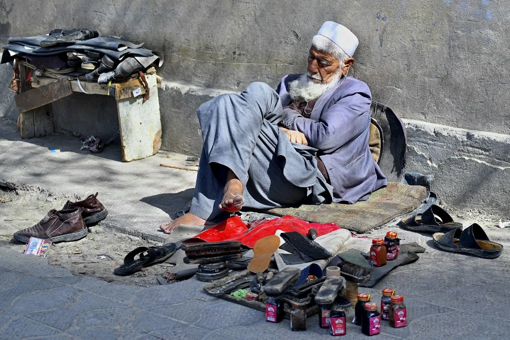 A cobbler takes a nap while waiting for customers along the roadside in Kabul. (File/AFP)