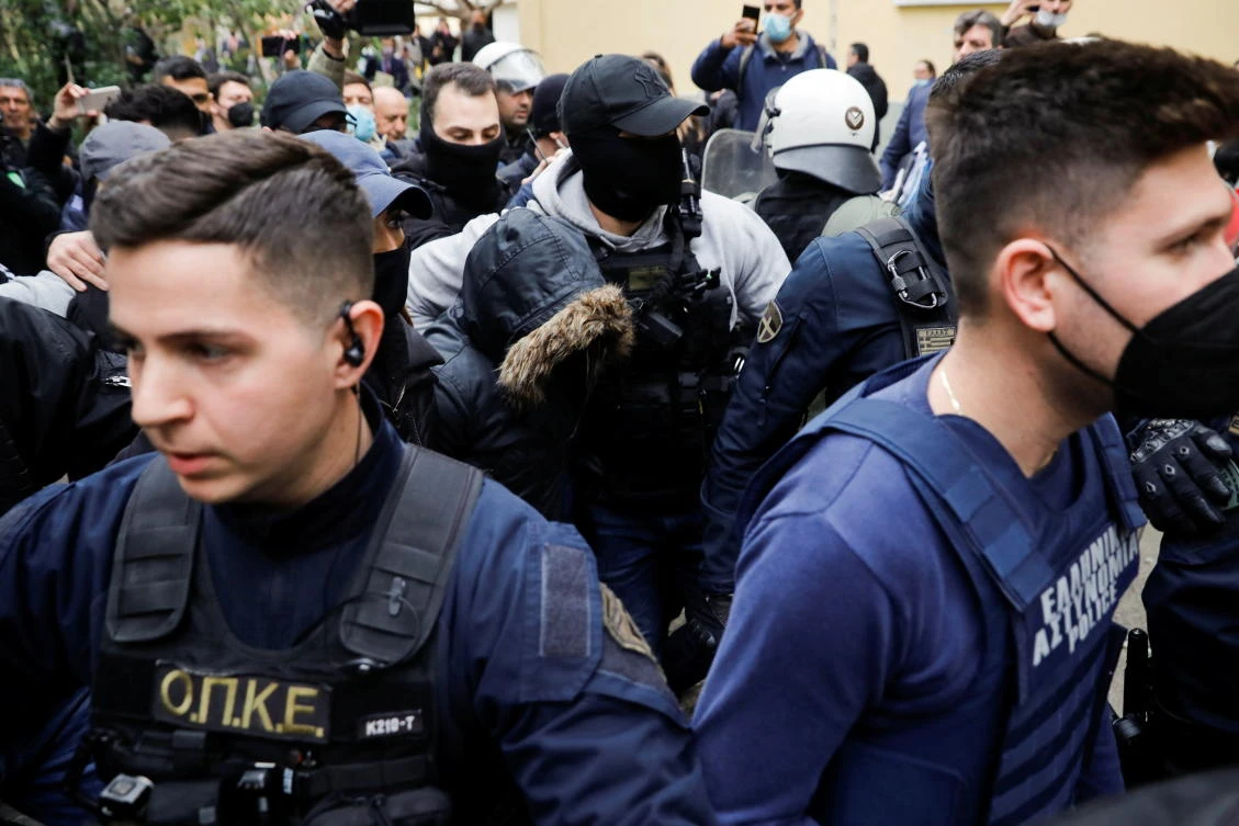 The woman was wearing a hood and a protective vest as authorities held back a crowd of onlookers and journalists. (AFP)