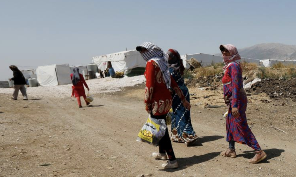 Syrian refugee women walk together at a camp for Syrian refugees near the town of Qab Elias, in Lebanon's Bekaa Valley. (Reuters/File)