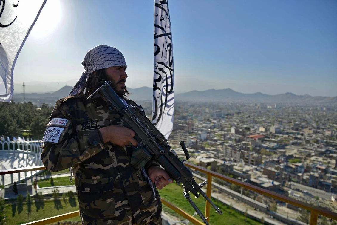 Above, a Taliban fighter stands guard at the venue for a flag hoisting ceremony of the Taliban flag on the Wazir Akbar Khan hill in Kabul on March 31, 2022. (AFP)