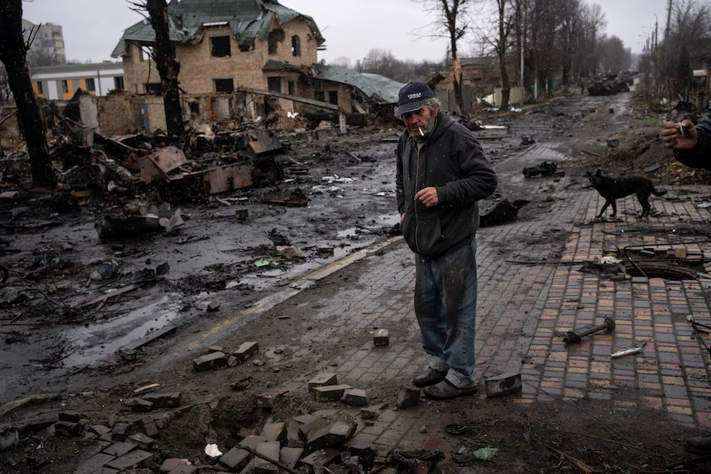 Konstyantyn, 70, smokes a cigarette amid destroyed Russian tanks in Bucha, in the outskirts of Kyiv, Ukraine. (AP)