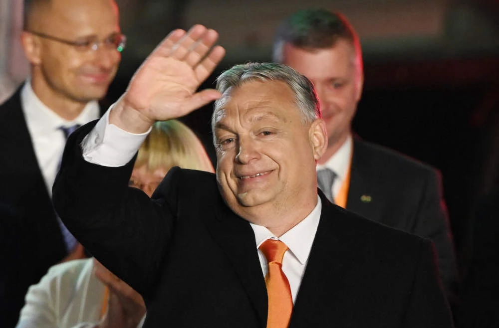 Hungarian Prime Minister Viktor Orban and members of the Fidesz party celebrate on stage at their election base, 'Balna' building on the bank of the Danube River of Budapest, on April 3, 2022. (AFP)