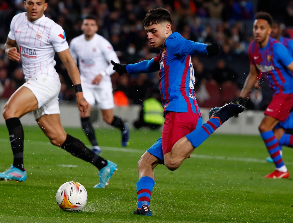 Barcelona’s Pedri, center, shoots on target during the Spanish La Liga match between Barcelona and Sevilla at the Camp Nou stadium in Barcelona on April 3, 2022. (AP)