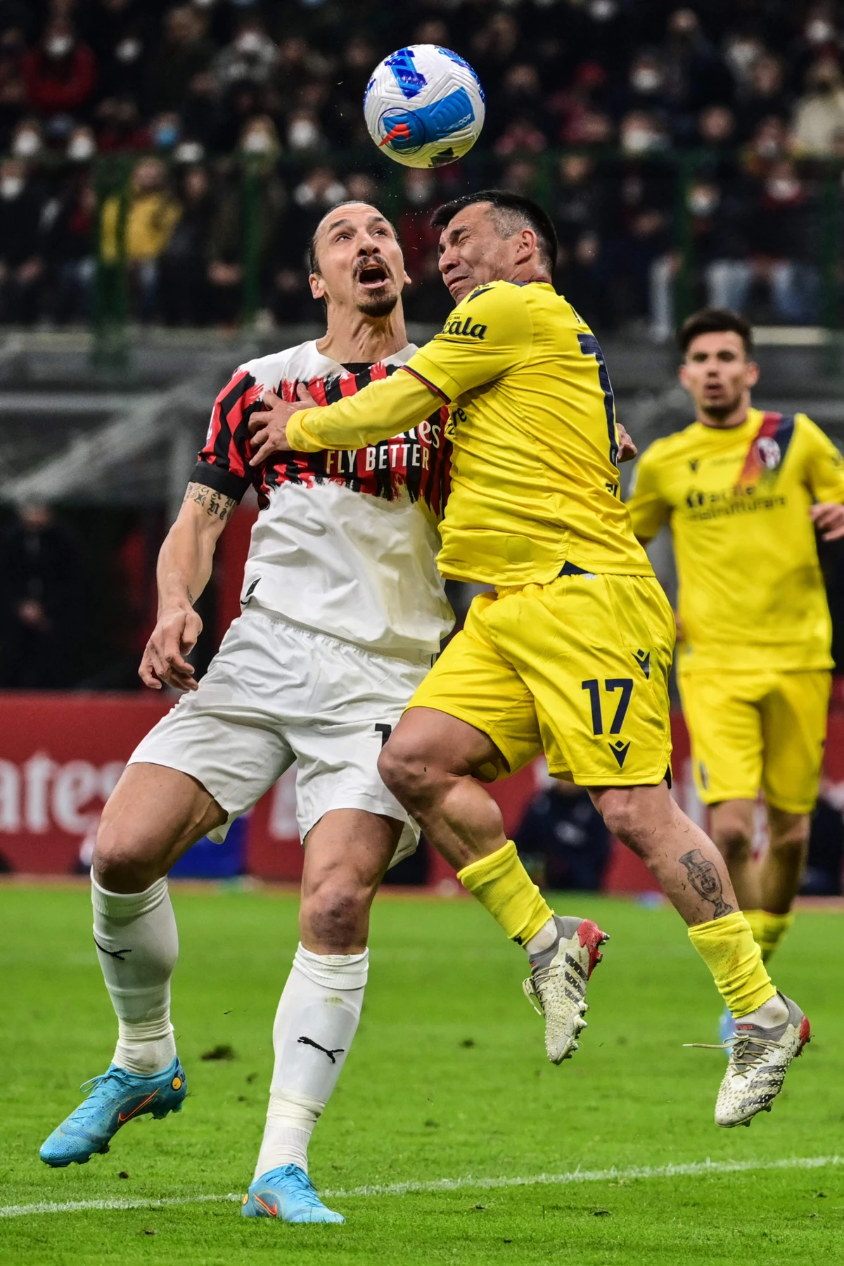 AC Milan's Swedish forward Zlatan Ibrahimovic, left, and Bologna's Chilean defender Gary Medel collide as they go for a header during the Italian Serie A football match between AC Milan and Bologna on April 4, 2022 at the San Siro stadium in Milan. (AFP)