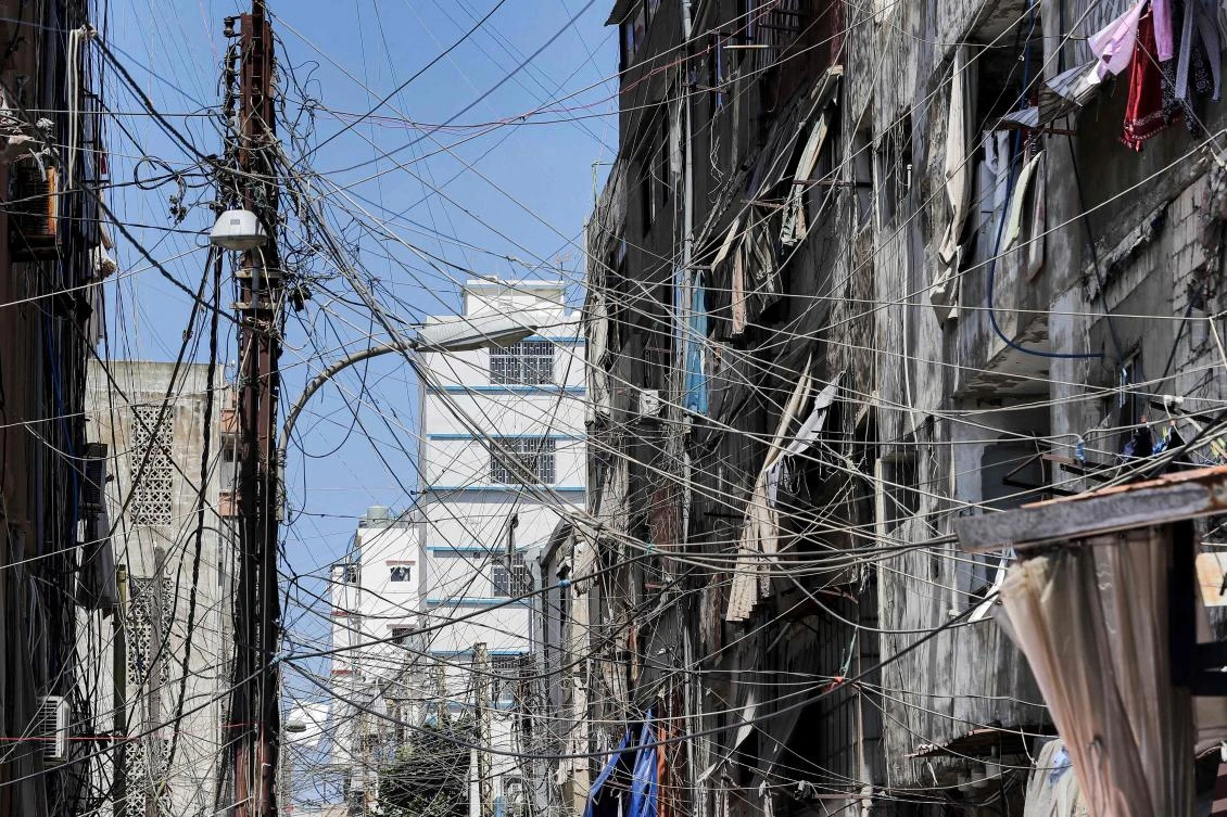 This file photo taken on June 23, 2021 shows a view of a mesh of raised electricity lines along a street in a suburb of Lebanon's capital Beirut. (AFP)