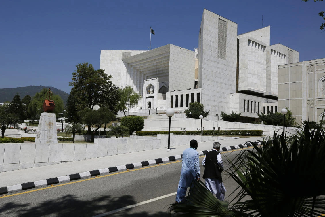 People walks past the Supreme Court where a petition hearing to dissolve parliament by country's Prime Minister is taking place in Islamabad, Pakistan, Monday, April 4, 2022. (AP)