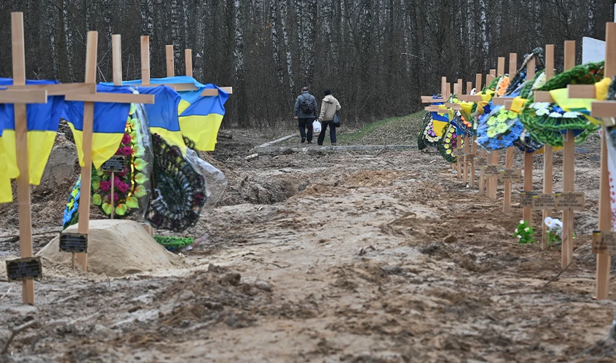 Resident walk past graves in a cemetery in Chernigiv, northern Ukraine, on April 5, 2022. (AFP)