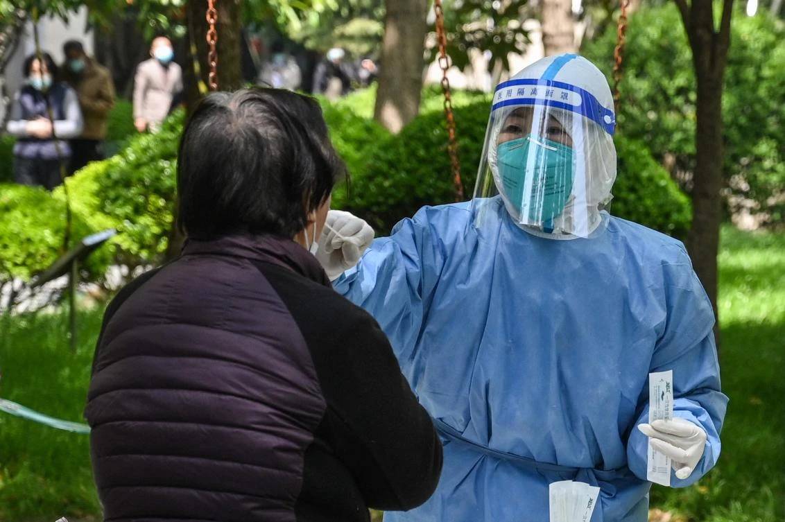 A health worker conducts a swab test for the Covid-19 coronavirus at a residential compound during the second stage of a pandemic lockdown in Shanghai on Wednesday. (AFP)