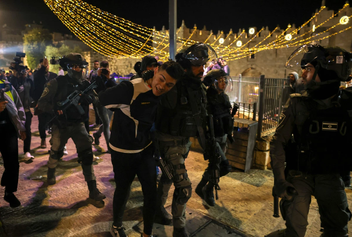 Israeli security forces detain a young Palestinian during clashes in front of Damascus gate which leads to Jerusalem's old city on April 6, 2022. (AHMAD GHARABLI / AFP)