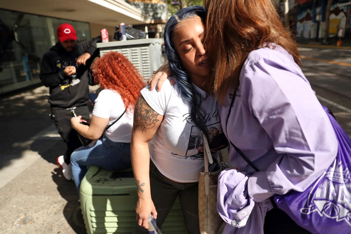 Relatives of victims in the recent mass shooting in Sacramento, California, console each other on April 5, 2022 at the scene of the violence. (Scott Strazzante/San Francisco Chronicle via AP)