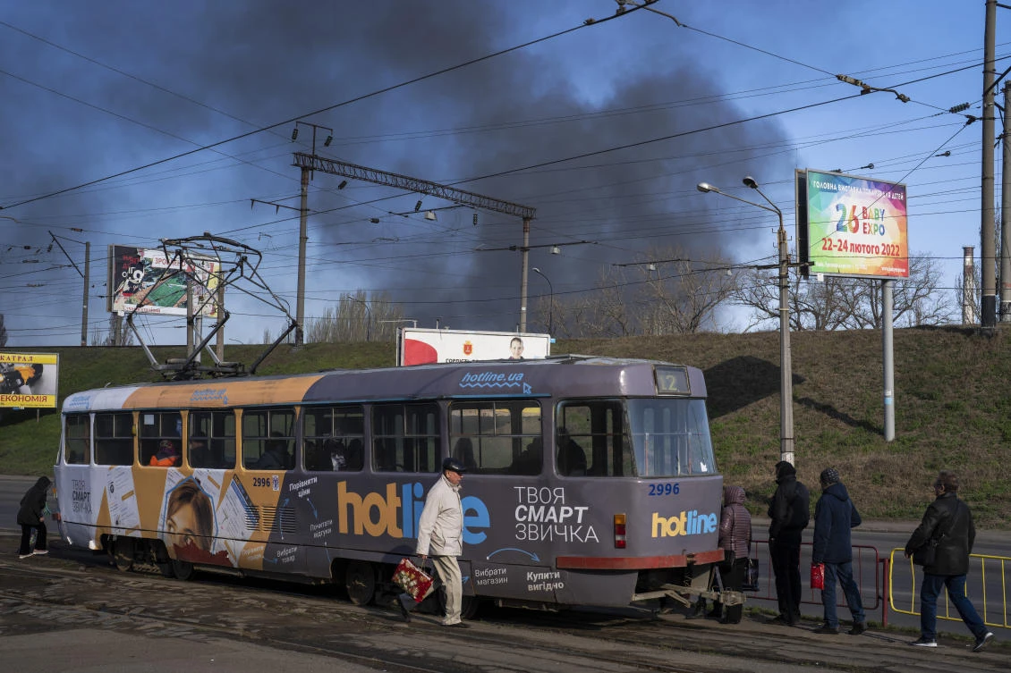 People board a tram, as smoke rises in the air following a Russian attack a day before, in Odesa, Ukraine on April 4, 2022. (AP)