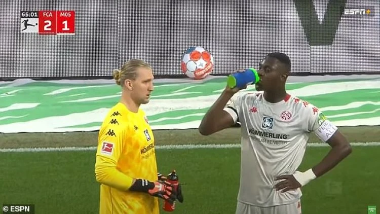 Moussa Niakhate takes a drink while speaking to Mainz goalkeeper Robin Zentner. (Screengrab)