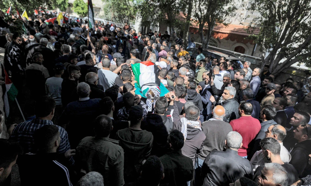 Mourners carry the body of Palestinian lawyer Mohammed Assaf during his funeral in the village of Kafr Laqif near Qalqilya in the northwest of the occupied West Bank on April 13, 2022. (AFP)