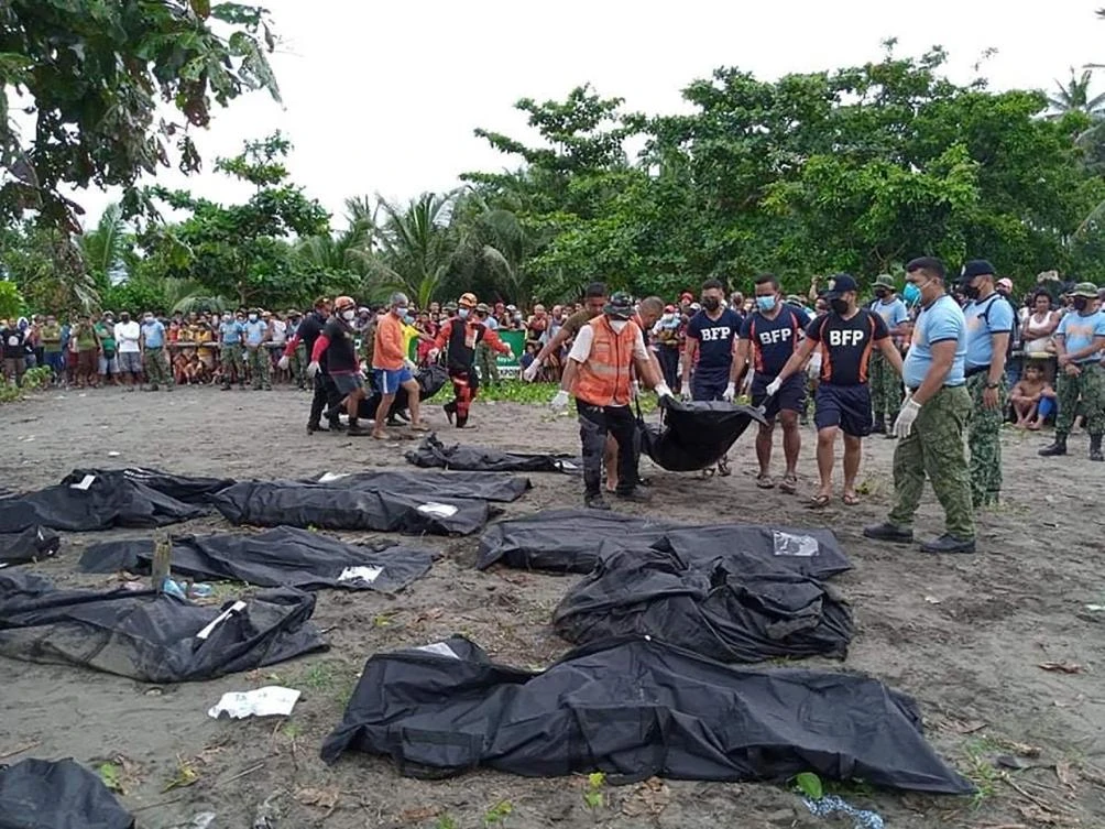 Rescuers carry a body bag containing a victim of a landslide that slammed the village of Pilar in Abuyog town, Leyte province on April 13, 2022. (AFP)