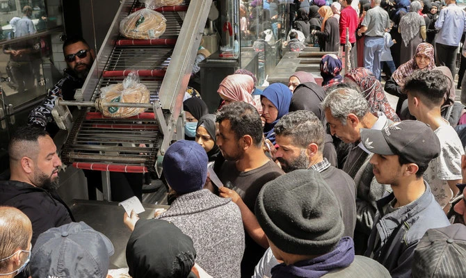 People queue to buy bread outside a bakery in Beirut on Tuesday. (Reuters)