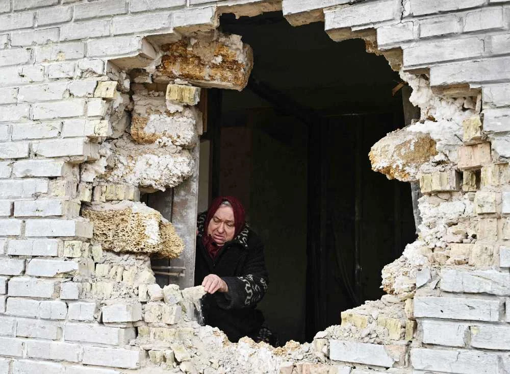 Local resident Nadiya, 65, shows a hole in a house after shelling in the village of Zalissya, northeast of Kyiv, on April 12, 2022. (AFP)