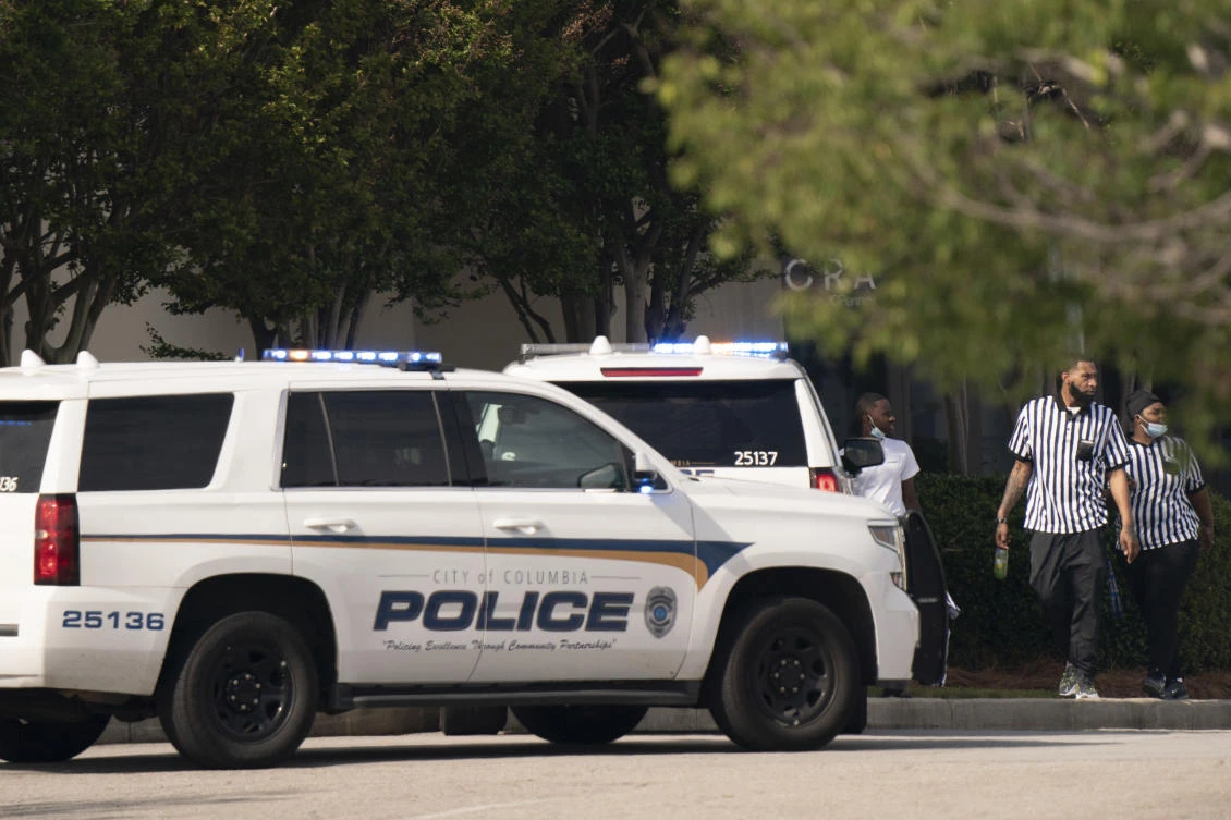 Store employees walk near police vehicles outside a shopping mall in Columbia, South Carolina following a shooting on April 16, 2022. (AP)
