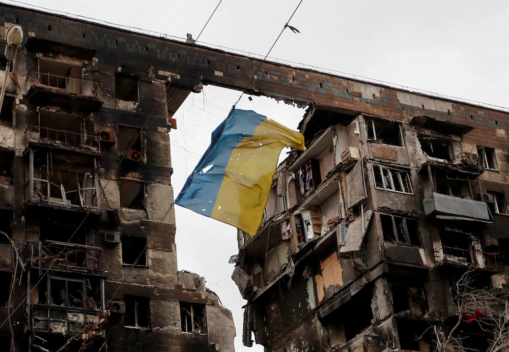 A torn flag of Ukraine hung on a wire in front an apartment building destroyed during Ukraine-Russia conflict in the southern port city of Mariupol. (Reuters)