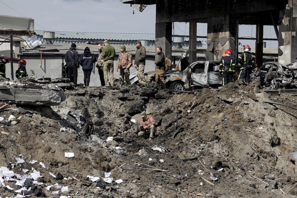 Ukrainian servicemen and rescuers inspect the site of military strikes on buildings in Lviv on April 18, 2022. (Reuters)