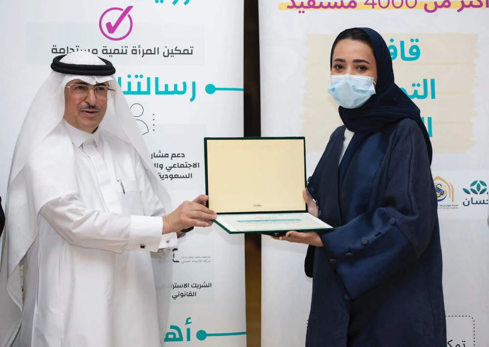 Thikra Al-Abdul Latif, director of the Food Empowerment Convoy 2022 project, receives a certificate of thanks from Abdul Wahab Mohammed Al-Faiz after the launch of the project on Sunday in Riyadh. (Supplied)