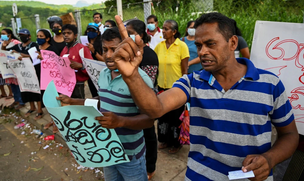 Demonstrators shout slogans in Rambukkana a day after police killed one person while dispersing a protest against the country’s worsening economic crisis. (AFP)