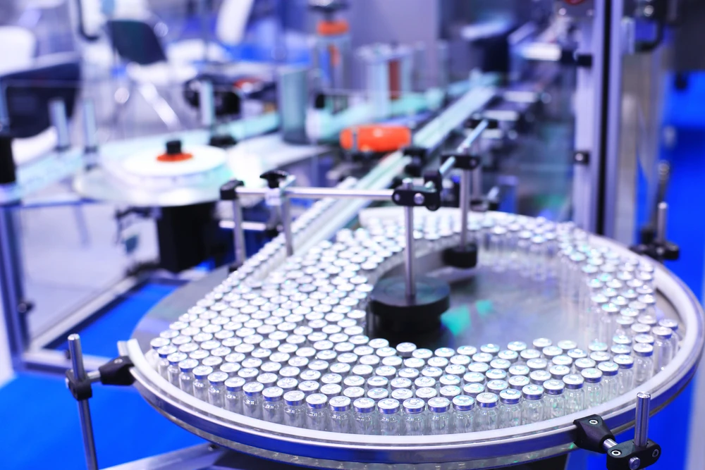 Factory for the production of medicines, glass bottles on the conveyor. Shutterstock