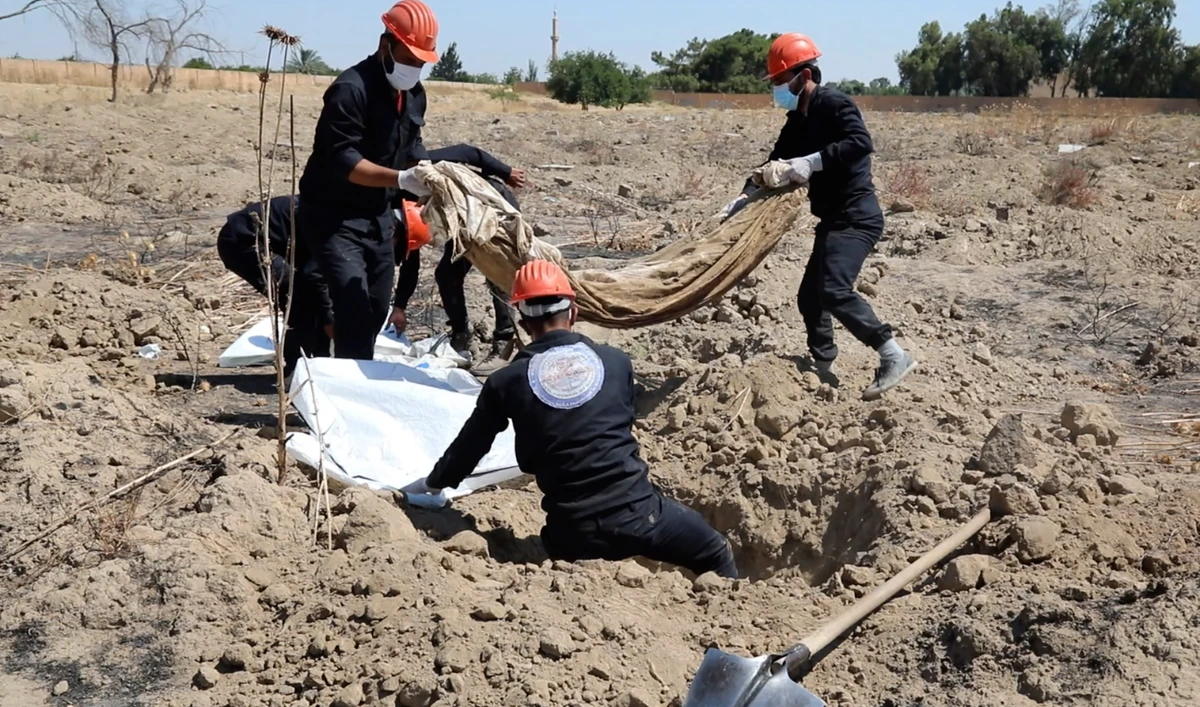 This frame grab from video, shows Syrian workers of the Civil Council of Raqqa digging for human remains at the site of a mass grave believed to contain the bodies of civilians and Daesh militants, in Raqqa, Syria, July 14, 2019. (AP/File)