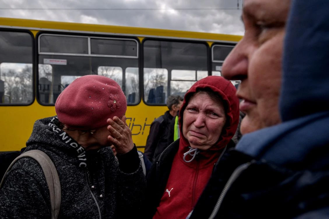 People fleeing fighting in the southern city of Mariupol meet with relatives and friends as they arrive in a small convoy that crossed through territory held by Russian forces. (File/AFP)