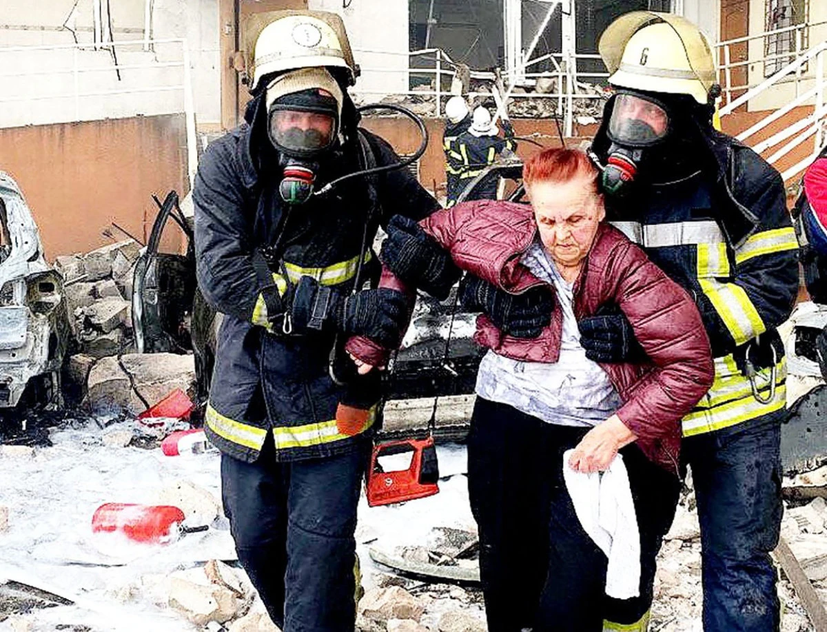 Ukrainian rescuers carry a woman out of a damaged building in Odessa on April 23, 2022, after a reported Russian missile strike. (Handout photo via AFP)