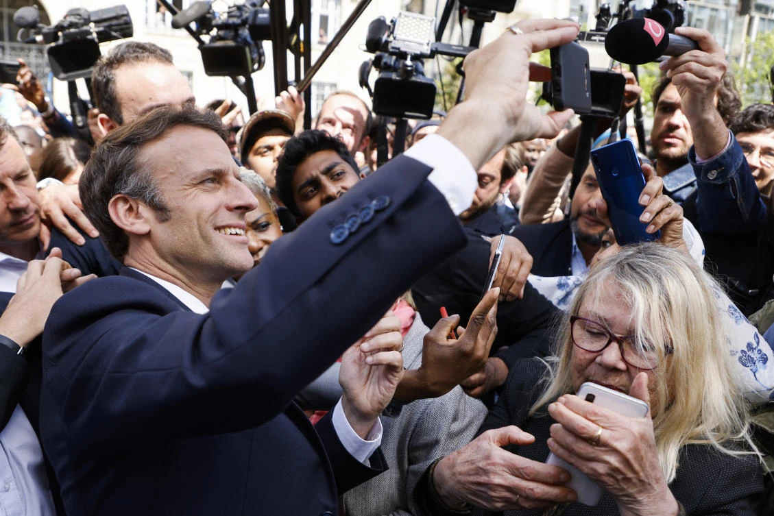 Centrist presidential candidate and French President Emmanuel Macron makes a selfie with residents during a campaign stop Thursday, April 21, 2022. (AP)