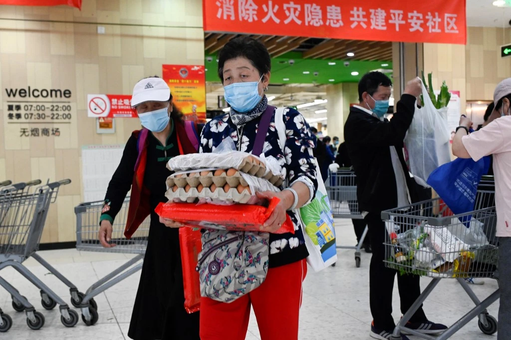 People shop at a supermarket in Beijing on April 25, 2022. (AFP)