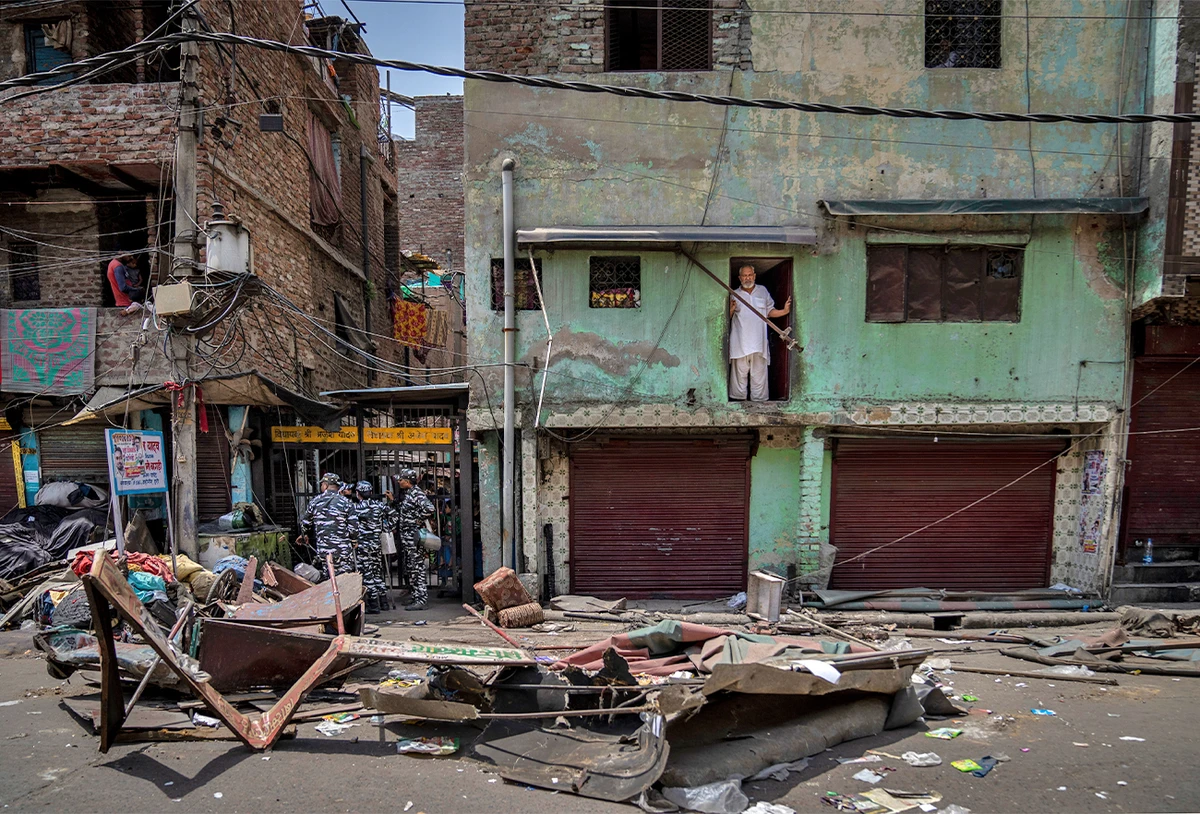 A Muslim man watches from his house after a shop was demolished in the area that saw communal violence during a Hindu religious procession on Saturday, in New Delhi's northwest Jahangirpuri neighborhood, in New Delhi, India, on April 20, 2022. (AP)
