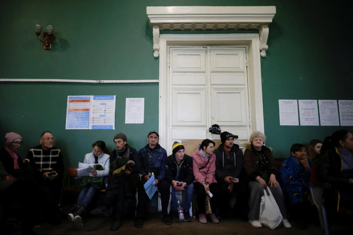 Ukrainian refugees wait to collect aid and register at a centre for internally displaced people, amid Russia's invasion of Ukraine, in the town of Kryvyi Rih, Dnipropetrovsk region, Ukraine April 25, 2022. (Reuters)