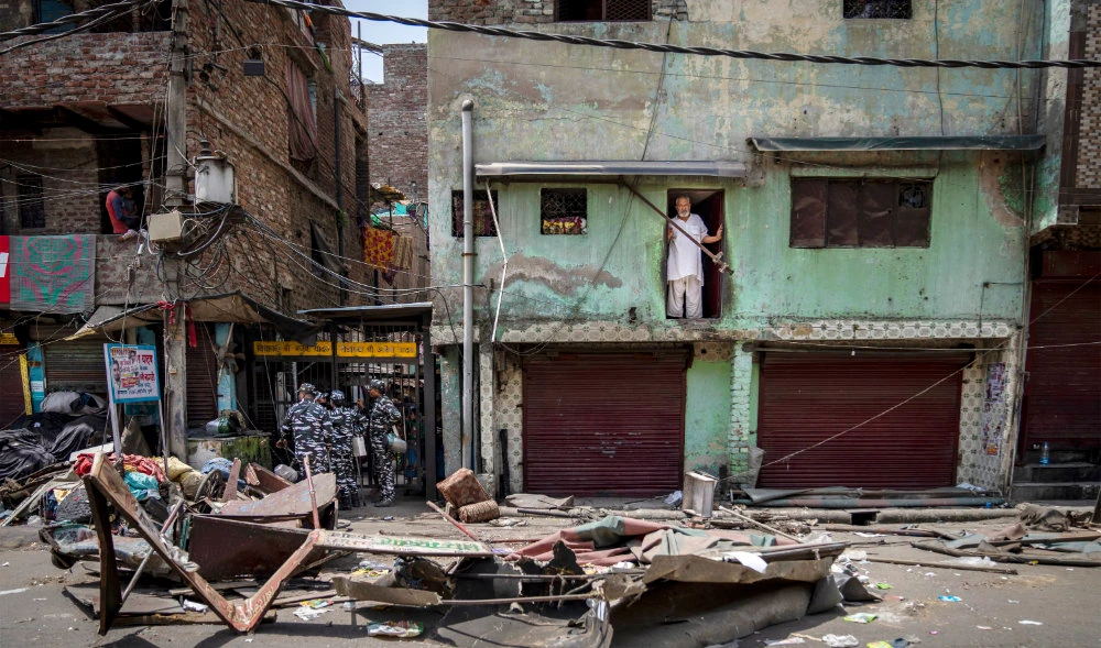 A Muslim man watches from his house after a shop was demolished in the area that saw communal violence during a Hindu religious procession in New Delhi's northwest Jahangirpuri neighborhood, in New Delhi, India, April 20, 2022. (AP)