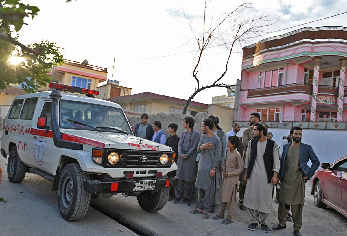 Onlookers stand next to an ambulance carrying victims near the site of a blast in Kabul, Afghanistan, on April 29, 2022. (AFP)