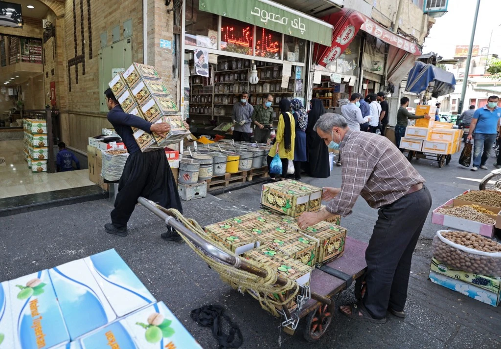 Iranian workers transport merchandise at the Molavi bazaar in southern Tehran on June 20, 2021. (File/AFP)