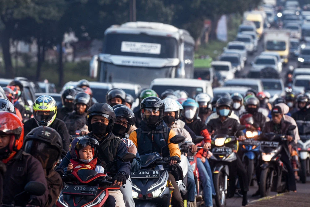 Motorists commute along a road in Nagreg, Indonesia on April 30, 2022, as people head to their hometowns to celebrate Eid Al-Fitr which marks the end of the holy fasting month of Ramadan. (AFP)