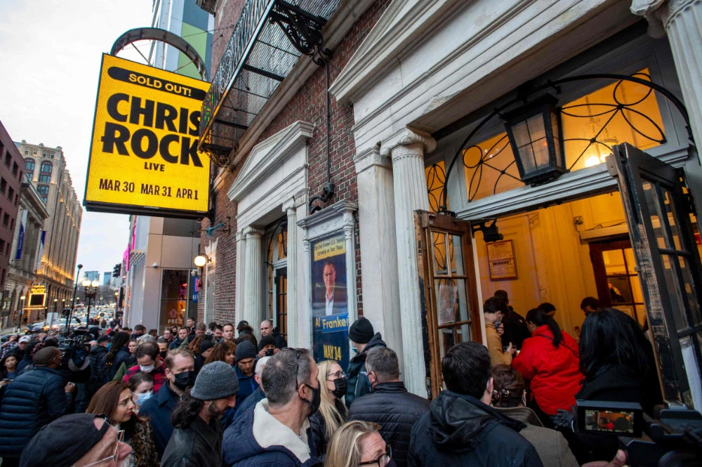 People wait in line to enter the Wilbur Theatre for a sold out performance by US comedian Chris Rock in Boston, Massachusetts on March 30, 2022. (AFP)