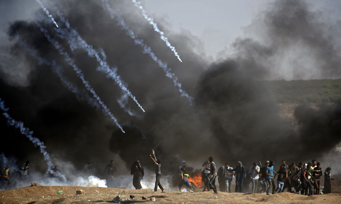 In this 2018 photo, Palestinians are met with a hail of tear gas as they protest in Gaza against Israeli atrocities. (AFP file)
