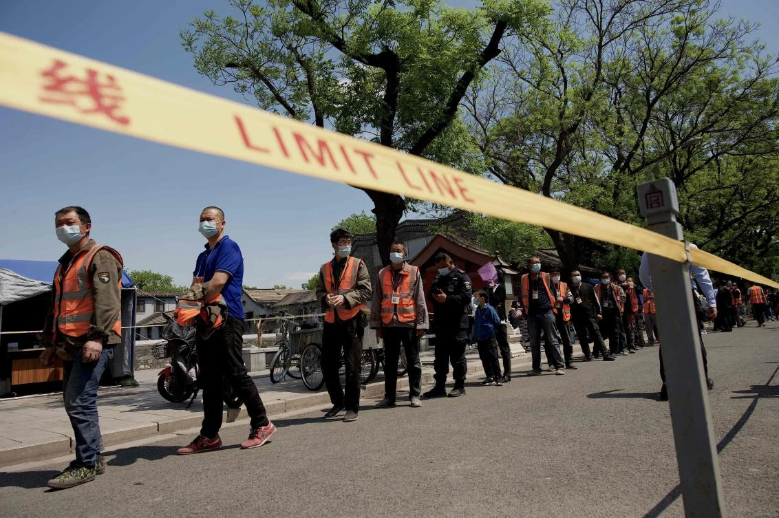 Beijing tightened social distancing rules and launched a fresh round of mass testing in its most populous and worst-hit district. People queue for a COVID-19 swab test near the entrance of the Forbidden City on May 1, 2022. (AFP)