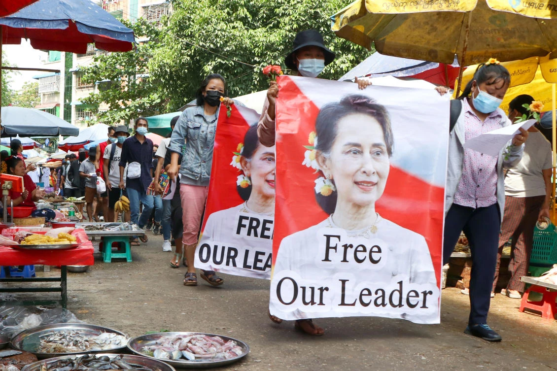 Protesters walk through a market with posters of ousted Myanmar leader Aung San Suu Kyi at Kamayut township in Yangon, Myanmar, April 8, 2021. (AP Photo)