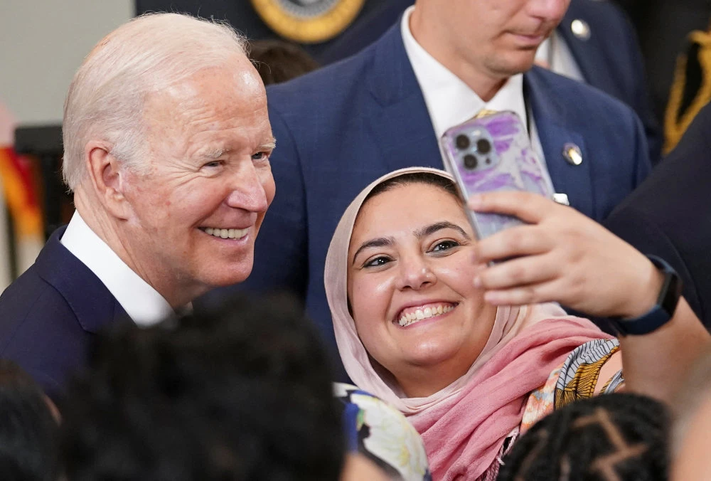 US President Joe Biden poses for a selfie while hosting a reception to celebrate Eid Al-Fitr at the White House in Washington, US, May 2, 2022. (Reuters)