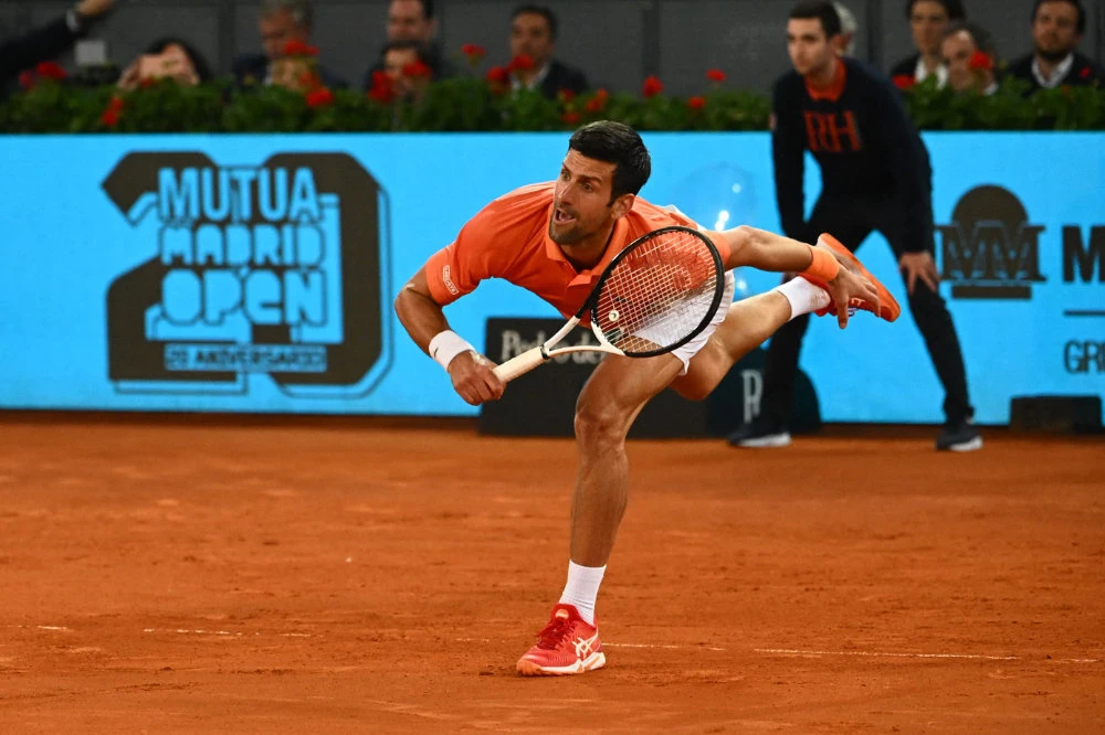 Serbia's Novak Djokovic returns the ball to France's Gael Monfils during their 2022 ATP Tour Madrid Open tennis tournament singles match at the Caja Magica in Madrid on May 3, 2022. (AFP)