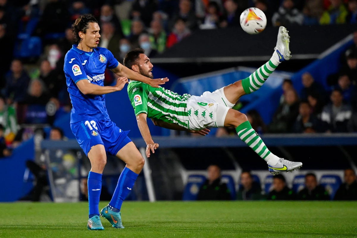 Real Betis' Spanish defender Victor Ruiz scissor-kicks the ball next to Getafe's Turkish forward Enes Unal during their Spanish League football match at the Col. Alfonso Perez stadium in Getafe on May 2, 2022. (AFP)