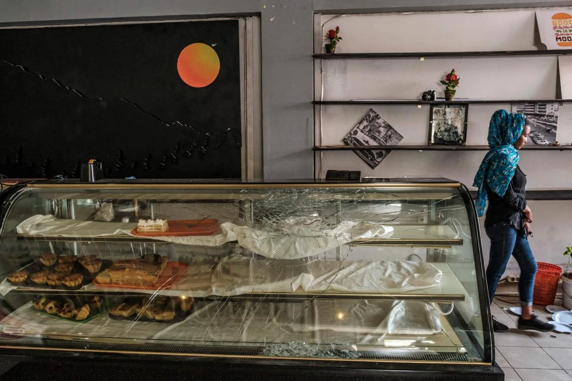 A worker walks behind a damaged displayer in a coffee shop in the city of Addis Ababa, Ethiopia, on May 03, 2022. (Photo by AFP)