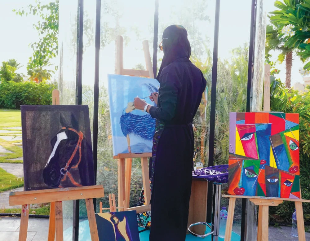 One of Saudi artist Meead Anwar Abulata’s live paintings portrayed a lady in a dress with hues of blue. (AN photo by Huda Bashatah)
