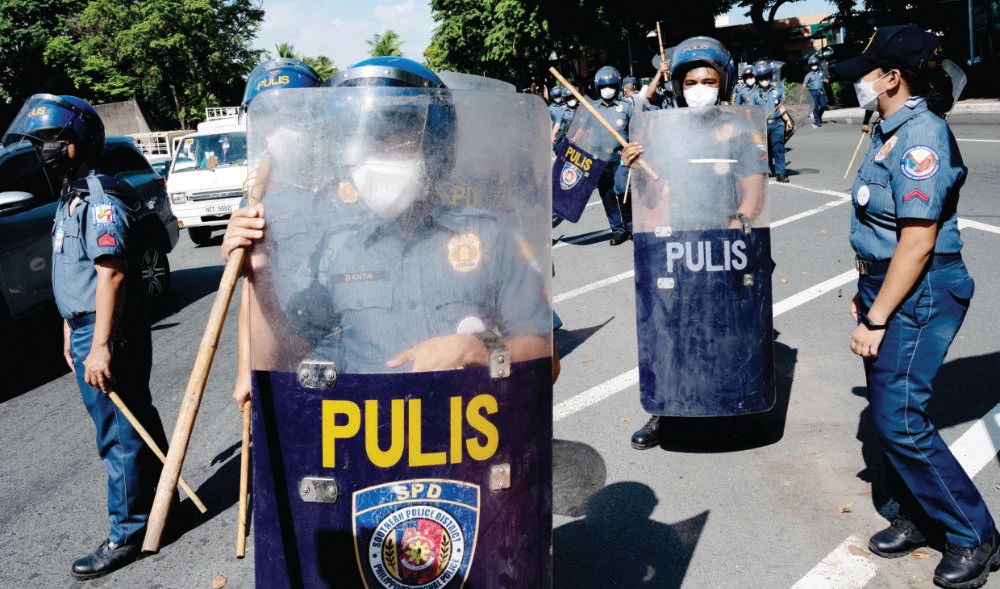 Police officers prepare to block demonstrators from marching near the Philippine International Convention Center during a rally on Friday in Metro Manila. (Reuters)