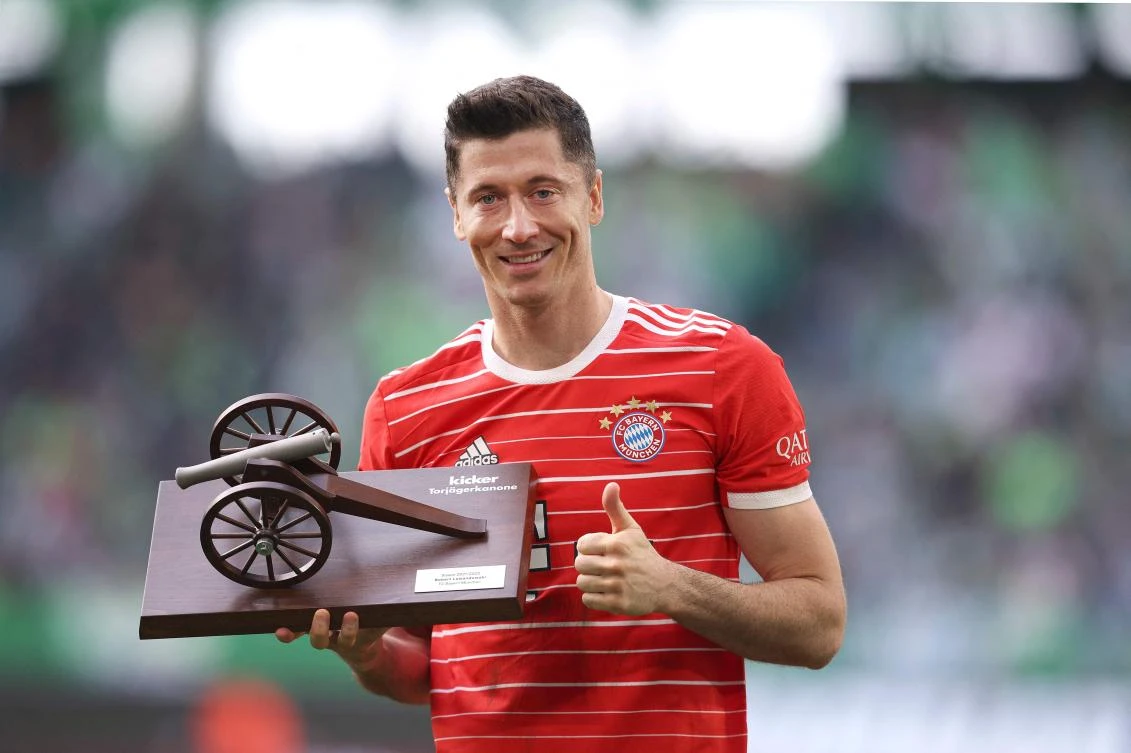 Bayern Munich's Polish forward Robert Lewandowski poses with the Top Scorer trophy, for finishing the season with the most goals scored in the German Bundesliga, after their match against VfL Wolfsburg on Saturday. (AFP)