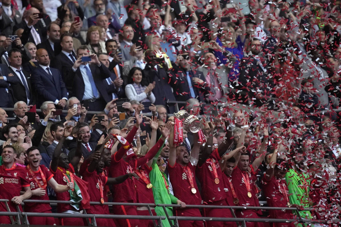 Liverpool players hold the trophy and celebrate after winning the English FA Cup final against Chelsea at Wembley stadium in London on Saturday. (AP)